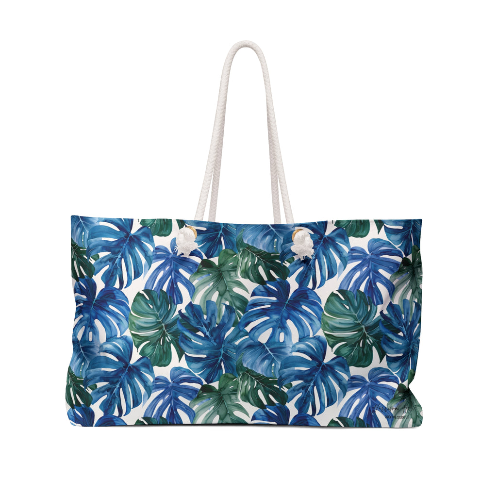 A Weekender Bag with Blue and Green Monstera leaves